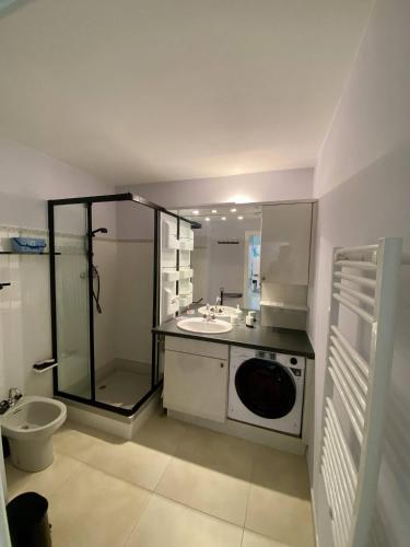 une salle de bain avec un lavabo et une machine à laver dans l'établissement Nice Ouest 2P Sea view, Pool, Quiet, à Nice