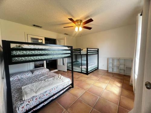 two bunk beds in a room with a ceiling fan at Bunk bed private room Ideal for Groups in SHARED home in San Antonio