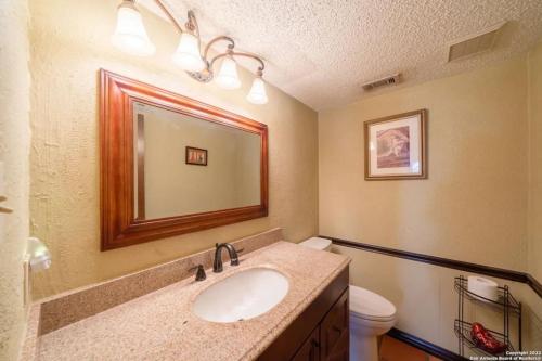 a bathroom with a sink and a toilet and a mirror at Bunk bed private room Ideal for Groups in SHARED home in San Antonio