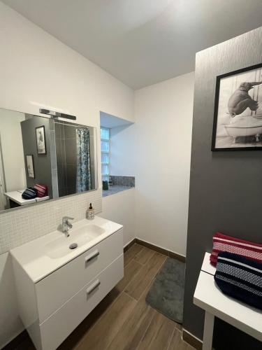 une salle de bain avec un lavabo blanc et un miroir dans l'établissement With us , your home nous chez vous, à Bécon-les-Granits