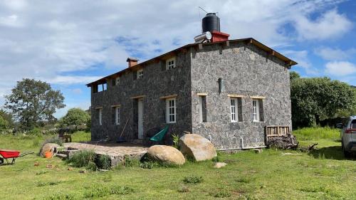 an old stone house in the middle of a field at Hermosa casa de campo a solo 90min de CDMX in San Lorenzo Octeyuco