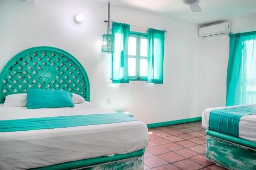 a bedroom with a bed with a green headboard at Hotel Costa 55 Puerto Escondido in Puerto Escondido