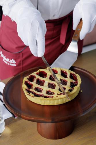 a person is cutting a pie with a knife at Glacier Premium Apartments in Bukovel