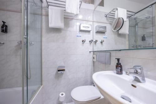 a bathroom with a shower and a sink and a toilet at Fletcher Waldhotel Nordrhein-Westfalen in Heiligenhaus