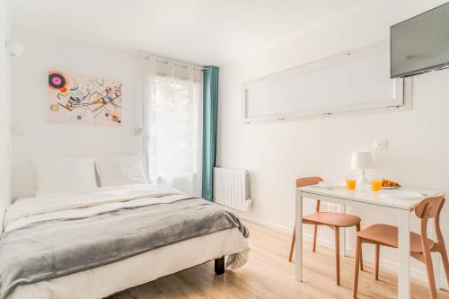 une chambre blanche avec un lit et une table dans l'établissement Résidence inner center Courbevoie, à Courbevoie