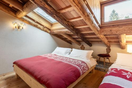 due letti in una stanza con soffitti in legno di CORTINA Lodge a Cortina dʼAmpezzo