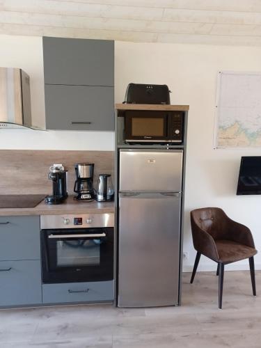 une cuisine avec une cuisinière et un micro-ondes dans l'établissement Quiet apartment, à Dinard