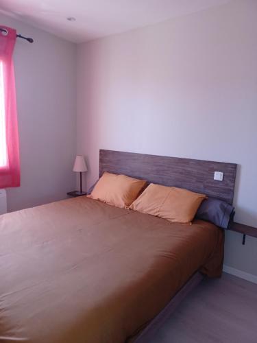 une chambre avec un grand lit avec une tête de lit en bois dans l'établissement Quiet apartment, à Dinard