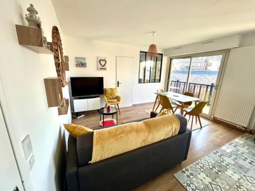 un salon avec un canapé et une table dans l'établissement Magnifique appartement vue mer à 50 m de la plage, à Villers-sur-Mer
