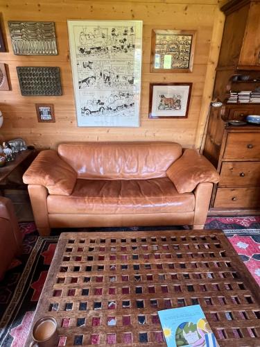 a living room with a leather couch in a room at Magnifique Chalet Gstaadt in Gstaad