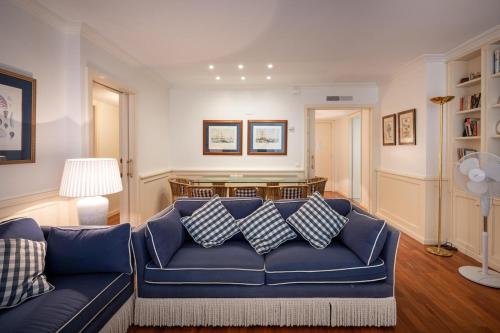 een woonkamer met een blauwe bank met kussens bij AT103 Pins Beachfront complex, beach view in Torredembarra