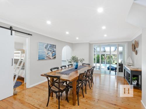 a kitchen and dining room with a wooden table and chairs at The Place in Summerland Point