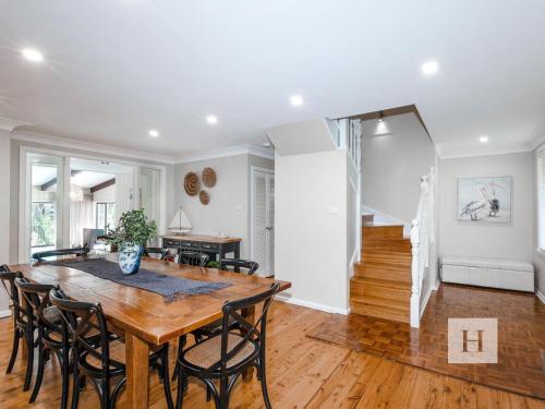 a dining room and living room with a table and chairs at The Place in Summerland Point