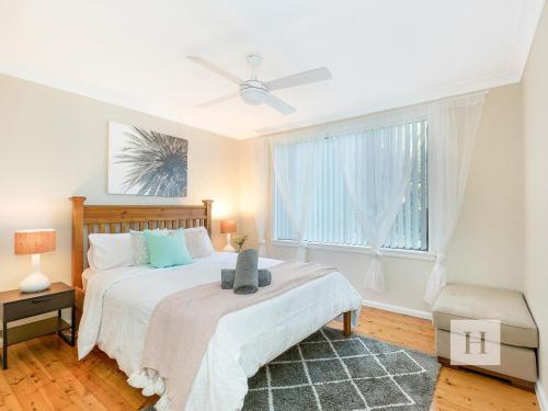 a bedroom with a large bed and a window at The Place in Summerland Point