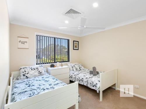 a bedroom with two beds and a window at The Place in Summerland Point
