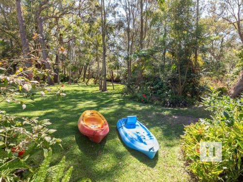 three kayaks sitting on the grass in a yard at The Place in Summerland Point