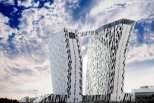 a tall glass building with a sky in the background at AC Hotel by Marriott Bella Sky Copenhagen in Copenhagen