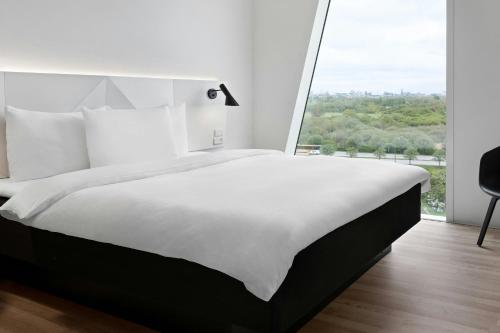 a large bed in a room with a large window at AC Hotel by Marriott Bella Sky Copenhagen in Copenhagen
