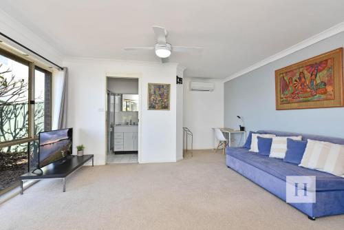 a living room with a blue couch and a tv at Sparkling Waters in Rathmines