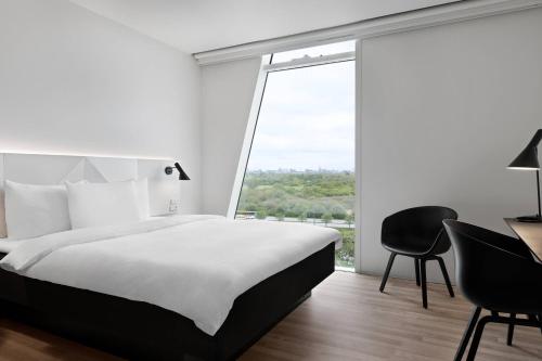 a hotel room with a bed and a desk and a window at AC Hotel by Marriott Bella Sky Copenhagen in Copenhagen
