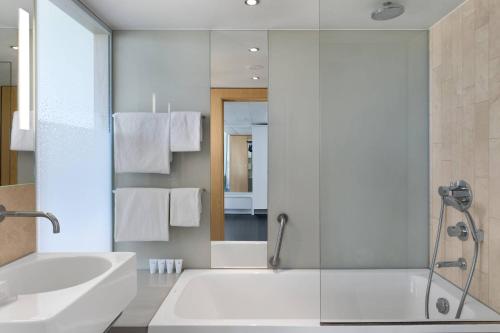a bathroom with a tub and a sink and a shower at AC Hotel by Marriott Bella Sky Copenhagen in Copenhagen