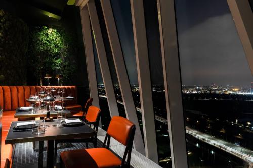 a restaurant with a view of a city at night at AC Hotel by Marriott Bella Sky Copenhagen in Copenhagen