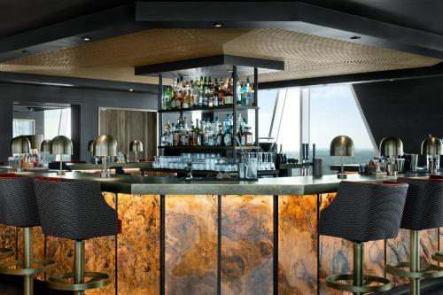 a bar in a restaurant with stools at AC Hotel by Marriott Bella Sky Copenhagen in Copenhagen