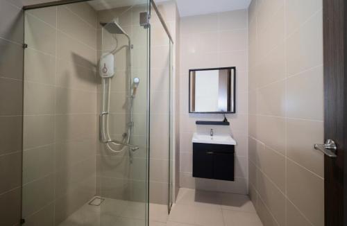 a bathroom with a glass shower and a sink at Sea View Cozy 2BR Green Haven -Permas Masai CIQ -7 to 9pax in Masai