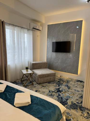 a bedroom with a bed and a tv and a chair at Strumica Jordan Luxury apartments in Strumica