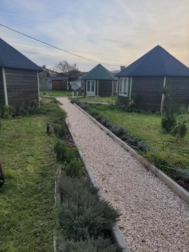 a gravel path in a yard with two houses at The Vie Llage - Olive Tree double bungalow in Vagos