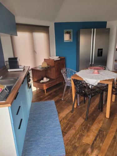 a kitchen and dining room with a table and refrigerator at The Vie Llage - Olive Tree double bungalow in Vagos