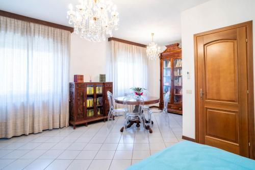 a dining room with a table and a chandelier at Casa Wanda in Oristano