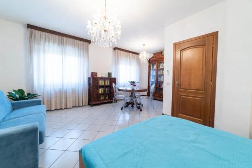 a living room with a blue bed and a chandelier at Casa Wanda in Oristano