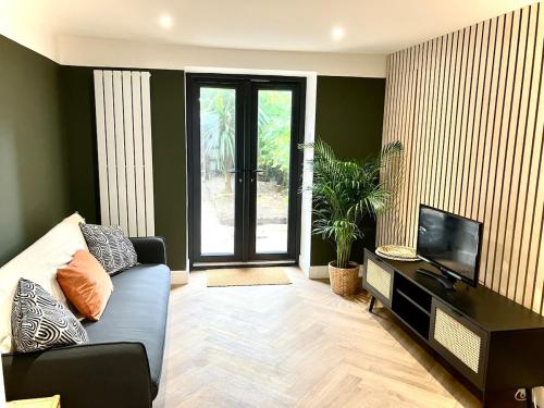 a living room with a couch and a television at City Centre Garden Apartment in Exeter