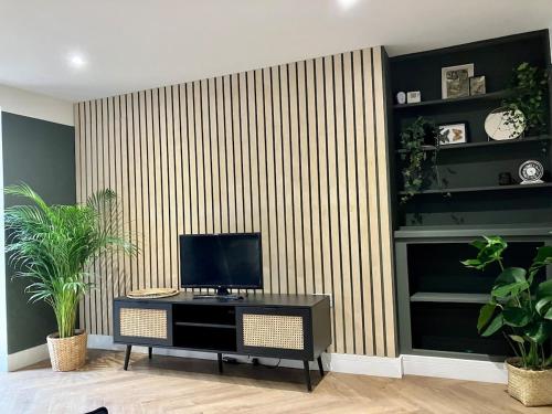 a living room with a tv on a wall at City Centre Garden Apartment in Exeter