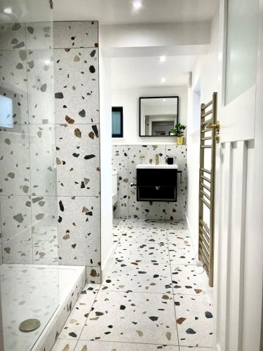 a bathroom with a walk in shower and a mirror at City Centre Garden Apartment in Exeter