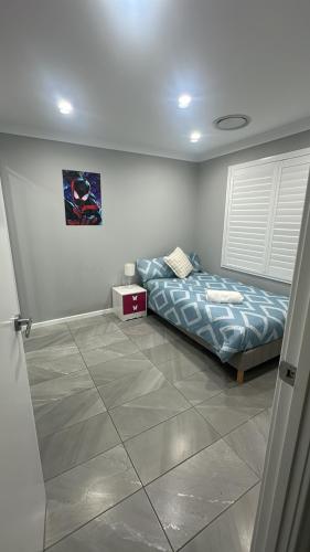 a bedroom with a bed in the corner of a room at Sair paradise in Marsden Park