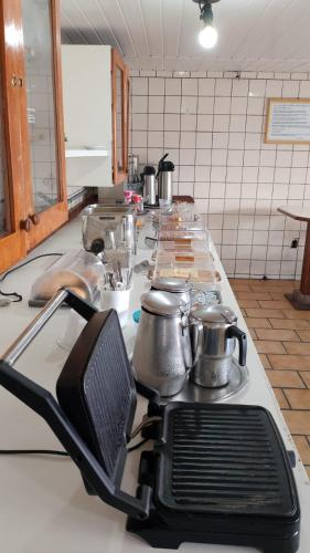 a kitchen with a counter with pots and pans at Hotel Veleiro in Florianópolis