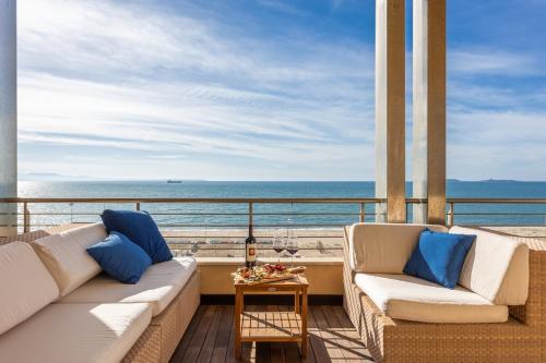 a balcony with two couches and a view of the ocean at Casa Futuro - Beautiful sea view with pool in Torre Grande