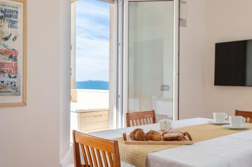a table with a plate of bread and a view of the ocean at Casa Futuro - Beautiful sea view with pool in Torre Grande