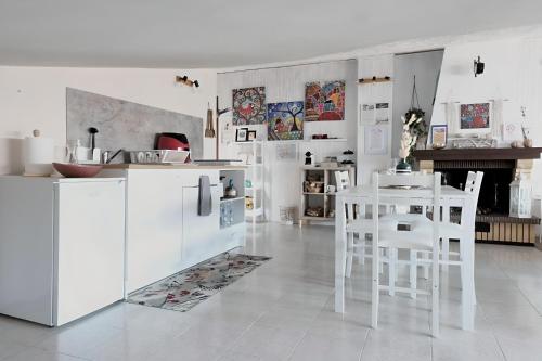 a kitchen with white appliances and a table and chairs at O' Frechete! in Sulmona