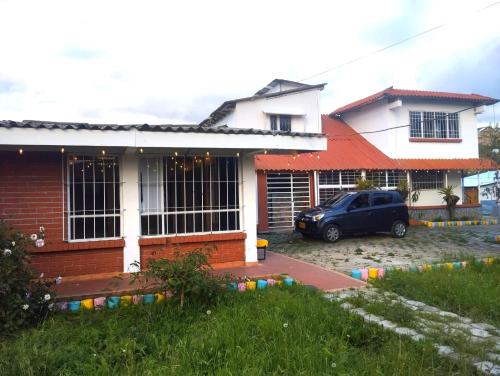 a car parked in front of a house at Hostal las margaritas in Pasto