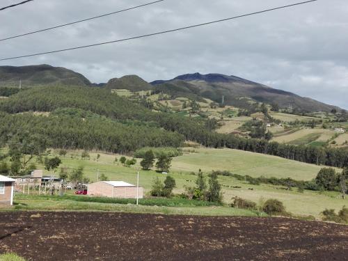 a view of a field with mountains in the background at Hostal las margaritas in Pasto