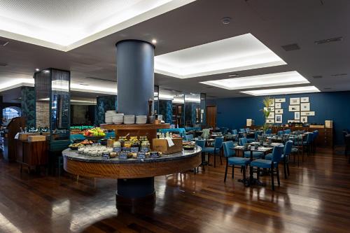 Un restaurante con mesas y sillas y un buffet. en Pestana Vintage Porto Hotel & World Heritage Site, en Oporto
