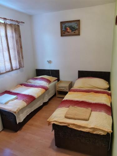 two twin beds in a room with a window at Penzion sklípek Mušov in Pasohlávky
