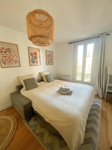 une chambre avec un grand lit et une fenêtre dans l'établissement Studio équipé St cloud proche Paris - La Défense, à Saint-Cloud