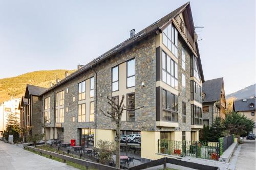 a large brick building with windows on a street at Aparthotel Nou Vielha in Vielha