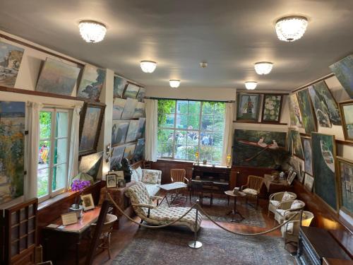 a room with a lot of paintings on the walls at Domaine Spa Perret-3Ha-Château ArtDéco MasterSuite B&B ou Gîte de Charme-À3Mn Giverny-Jardins Monet-Le Vexin-Piscine Chauffée en Haute Saison-Aire Enfants-PingPong-Options Dîner-Billard-Massage-Yoga-Coaching-Fitness-Sauna-Hammam-Promo2Nuits Jacuzzi inclus in Sainte-Geneviève-lès-Gasny