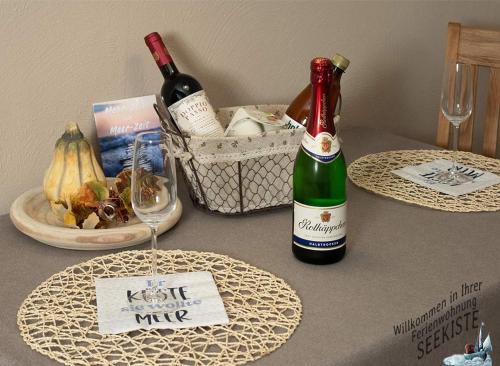 a table with two bottles of wine and a basket of food at Seekiste in Schleswig