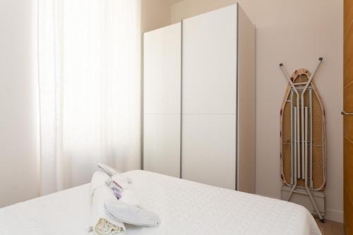 une chambre avec un lit blanc et un placard dans l'établissement Le Cosy YourHostHelper, à Cannes